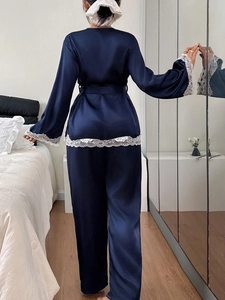 Detail view of navy blue silk pajama set with elegant white lace trim on the sleeve back