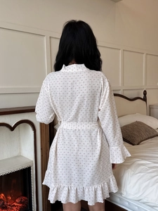 Detail view of cotton cloud robe featuring pink floral print and elegant ruffle hem design