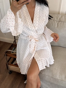 Close-up detail of white seersucker robe with pink bow print and ruffled sleeve edges