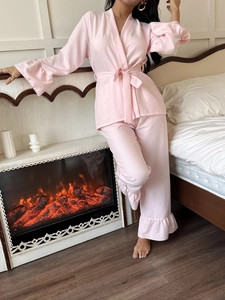 Detailed texture of pink seersucker pajama set featuring ruffled cuffs and wrap belt tie