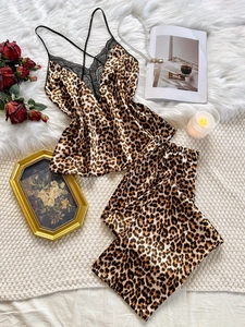 Detailed view of leopard print pajamas with black lace trim and silk satin fabric texture