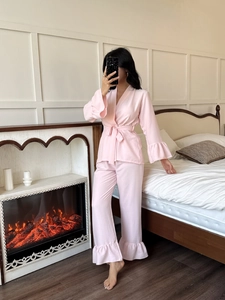 Pink seersucker pajama set featuring a tie-waist kimono top and ruffle hem trousers
