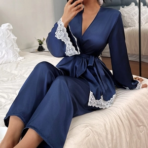 Navy blue silk-like satin pajama set with white lace trim and long sleeve tie-front design