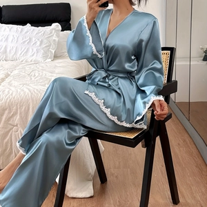 Blue satin pajama set with lace trim featuring a wrap top and matching long pants