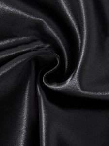 Détail macro du luxueux tissu en satin de soie noir avec texture lisse et drapé élégant