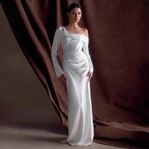 Detail of white satin one-shoulder dress with elegant ruched waist and long sleeve
