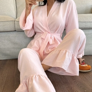 Pink seersucker pajama set for women with tie-waist top and ruffle hem trousers