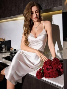 Detailed view of white silk nightdress featuring delicate lace trim on the V-neckline