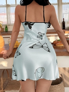 Dettaglio della schiena della camicia da notte in raso azzurro con motivi di farfalle nere
