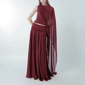 Detail of elegant burgundy two-piece set featuring pleated maxi skirt and sheer draped top