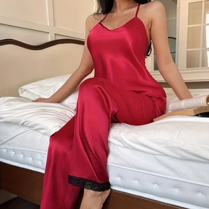 Women's red satin pajama set with V-neck camisole and black lace-trimmed pants