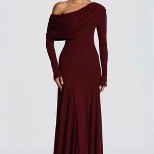 Detail view of burgundy ruched one-shoulder dress with elegant fishtail hemline