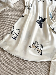 Gros plan sur un tissu satiné soyeux avec un imprimé papillon élégant sur un pyjama