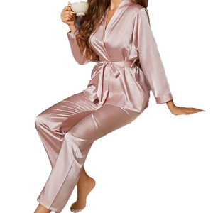 Pink satin pajama set with long sleeves and belted waist shown on model with silk finish
