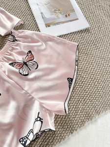 Détail du short de nuit en satin rose avec imprimé papillon et taille élastique douce