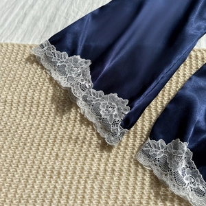 Navy blue satin robe featuring delicate white lace trim on sleeves over beige knit