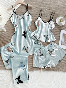 Ensemble de pyjama en satin à imprimé papillon disposé sur un tapis texturé blanc