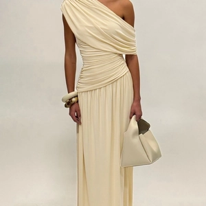Detail eines eleganten beige Maxikleids mit Schulterfrei-Design und feiner Plissee-Struktur
