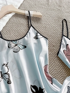 Détail de la nuisette en satin bleu clair avec imprimé papillon et bordure noire chic