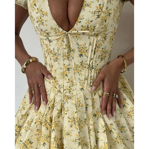 Detail of yellow floral dress showing corset waist design with delicate lace-up bust ties