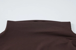 Dettaglio del tessuto a maglia marrone scuro con cuciture a pieghe e materiale elastico