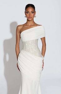 Détail de robe de soirée blanche à une épaule avec taille ornée de paillettes et plissée