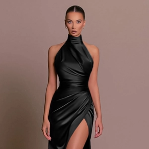 Detail of elegant black satin halter neck dress with pleated waist and high side slit