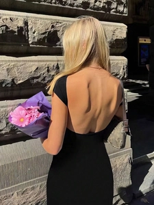 Primer plano de un vestido negro ajustado con diseño de espalda abierta en forma de U