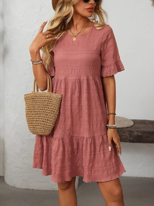 Detail view of pink pleated mini dress featuring ruffle sleeves and tiered cake skirt layers