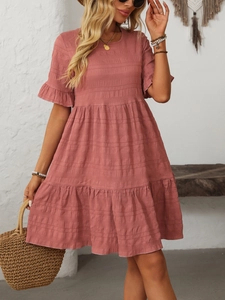 Detail of dusty pink tiered maxi dress with ruffled sleeves in a bohemian setting