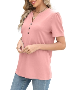 Detail of pink V-neck top with decorative brown buttons and subtle puff sleeve texture