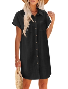 Detail of a black cotton linen shirt dress with buttons, flap pockets and a lapel collar
