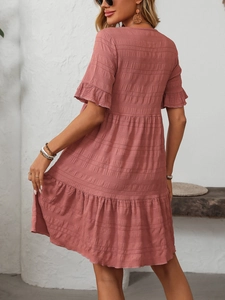 Detail of ruffled short sleeves and layered skirt on a pink pleated summer dress