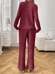 Detail of burgundy ribbed loungewear set featuring long sleeves and wide leg trousers