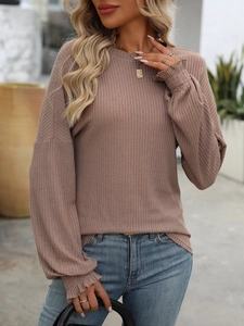 Detail of ribbed knit texture and ruffled cuffs on long sleeve casual crewneck top