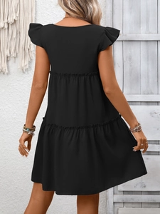 Détail d'une robe noire à volants avec manches papillon et tissu texturé vue de dos
