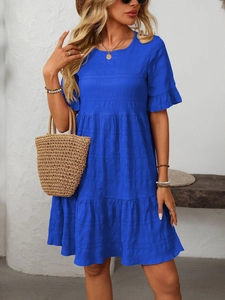 Detail of royal blue pleated dress featuring flutter sleeves and a tiered skirt design