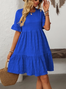 Detail of smocked texture and layered ruffle hem on cobalt blue bohemian midi dress