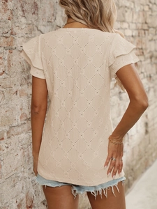 Dettaglio della trama a maglia a rombi traforata e maniche a balze su questo top beige