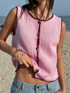Détail du gilet en tricot rose avec bordure au crochet violette et boutons marbrés