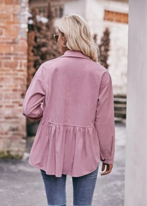 Detail view of pink corduroy babydoll shirt showing the pleated peplum waist and back texture