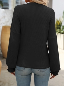 Detail of black ribbed knit long sleeve top showing the back fit and drop shoulder design