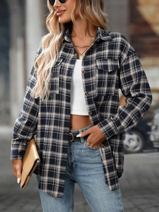 Detailed close-up of plaid flannel shirt featuring dual chest pockets and classic buttons
