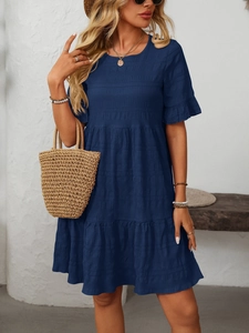 Detail of navy smocked dress with tiered skirt and ruffled sleeves in a summer resort style