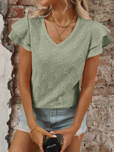 Dettaglio del top verde salvia con scollo a V, jacquard traforato e maniche a balze