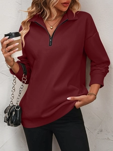 Detail of burgundy half-zip sweatshirt featuring ribbed cuffs and collar texture