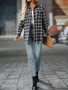 Detail of a casual plaid flannel shirt with front pockets and navy blue button-down collar