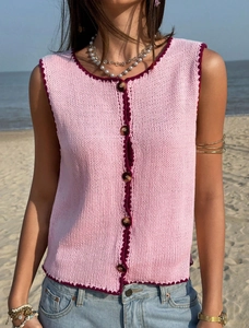 Détail du gilet en maille rose avec bordure au crochet bordeaux et boutons marrons
