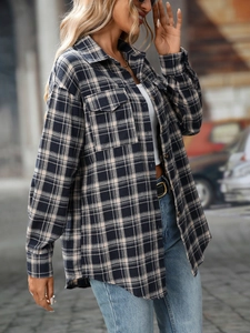 Detail of navy and beige plaid flannel shacket with flap pockets and curved hem design