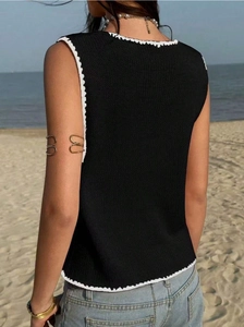 Détail du débardeur en maille noire avec bordure crochetée festonnée blanche